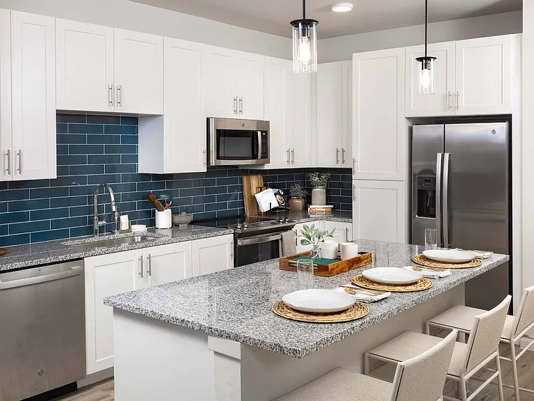 Cook with confidence in your contemporary kitchen, featuring sleek appliances and a stylish backsplash.