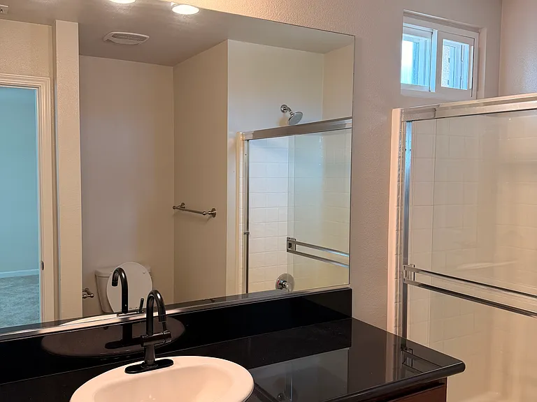 Primary bath with updated fixtures and granite countertops.