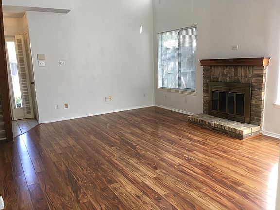 Living Room with Ceiling Fan, Laminate Floors, and Fireplace