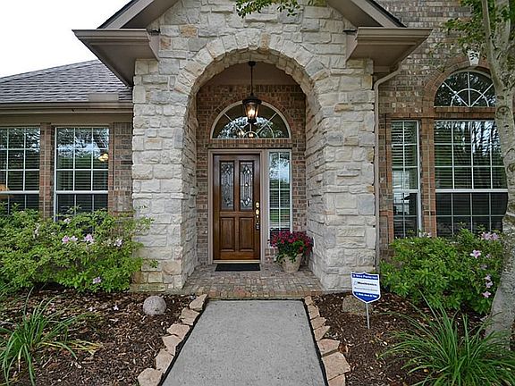 Arched natural stone front doorway . Says "WELCOME".