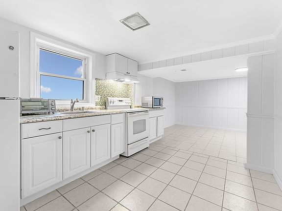 Upgraded kitchen with microwave, stove, refrigerator, disposal, sink and ample cabinetry. Room for large table.