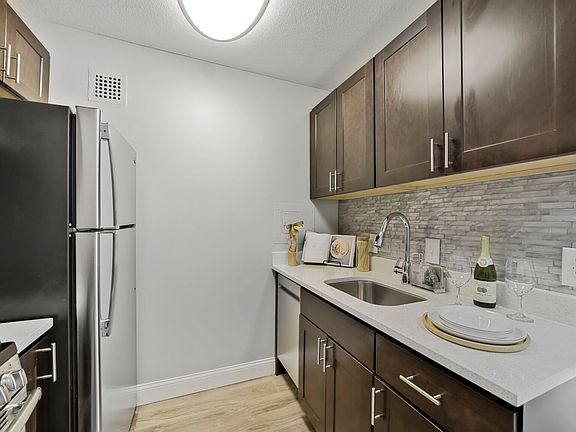 Alternate kitchen design with walnut stain cabinets and white quartz counters.