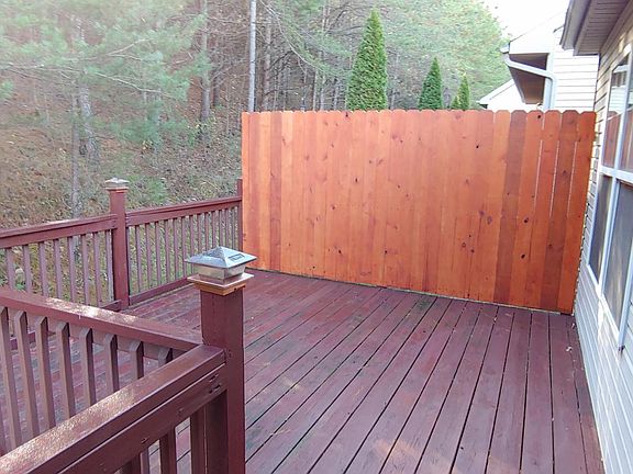 Deck faces wooded area.