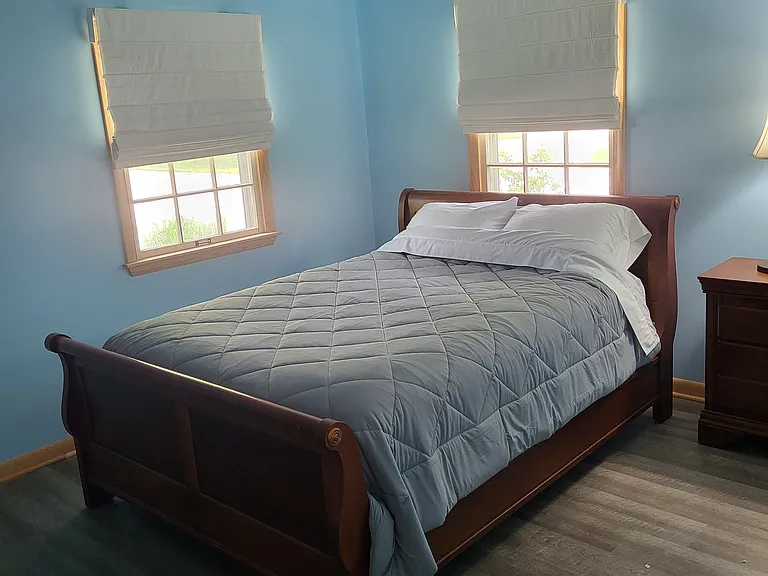 Master bedroom with queen sized bed and blackout blinds.