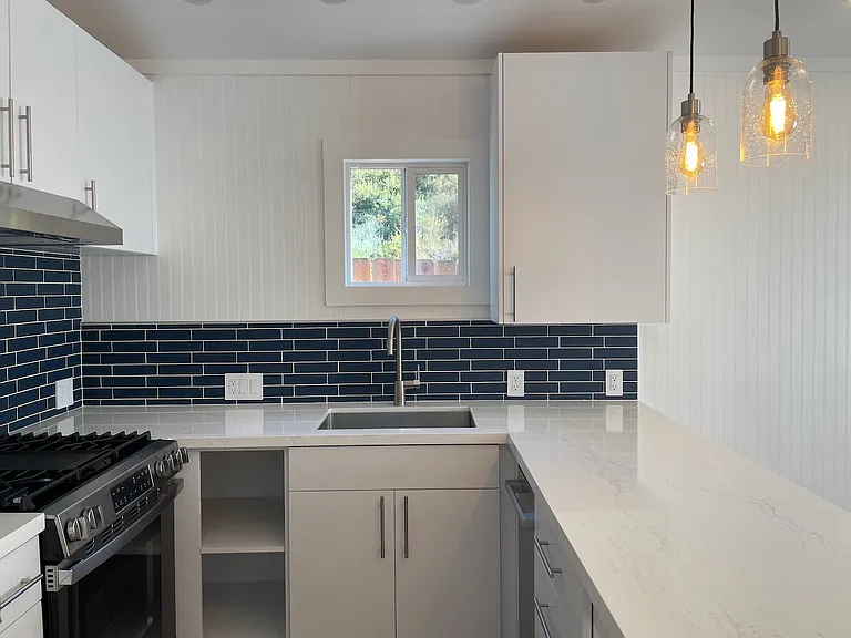 Chef's kitchen with large sink, dishwasher, gas range, range hood, and french door fridge/freezer.