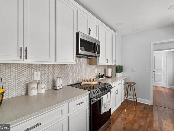 Beautiful white kitchen with quartz countertops and stainless steel appliances