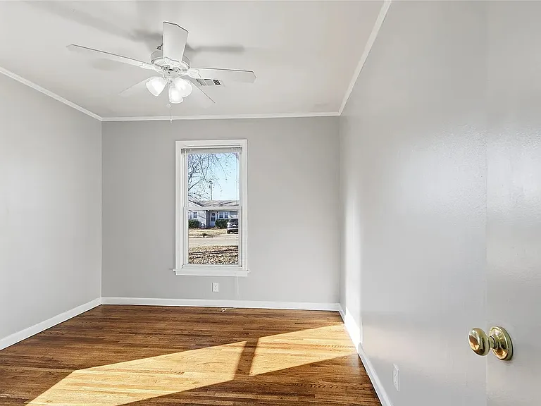 Bright bedroom with hardwood floors, generous closet space, and window blinds for comfort and convenience.