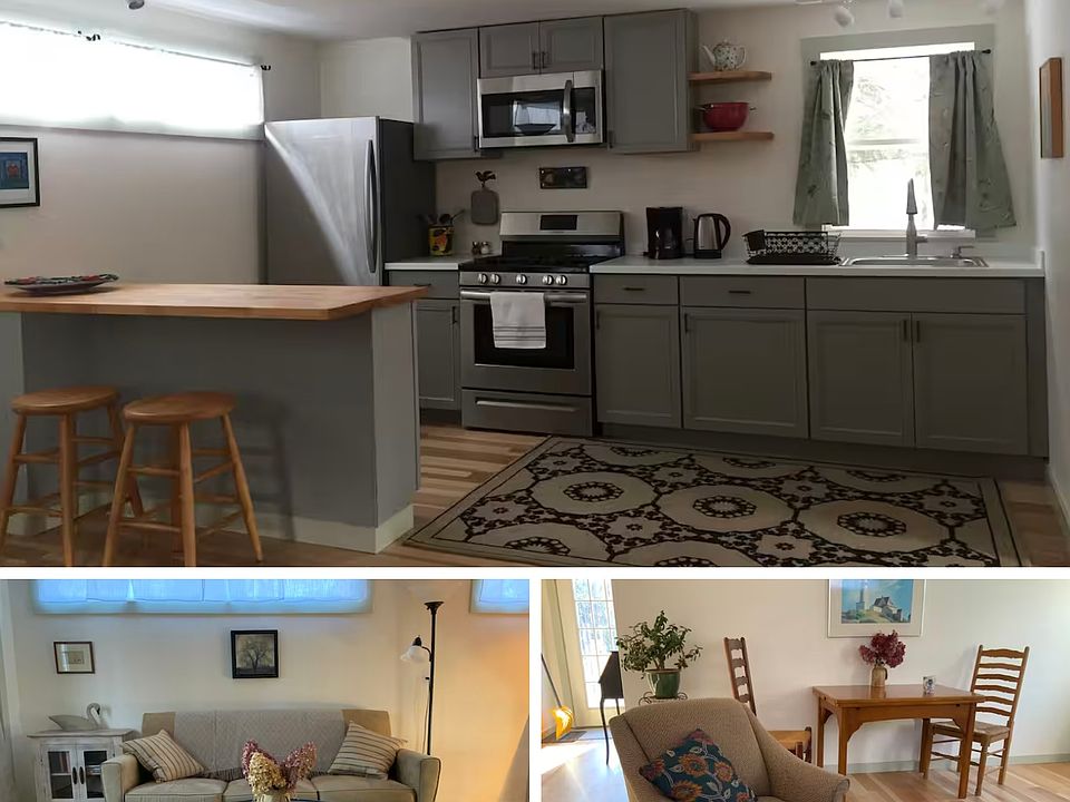 The cottage offers an open-plan space combining the kitchen and living room. The kitchen is equipped with a microwave, gas stove, and a counter with seating for two. The living area also includes a dining table with two chairs.