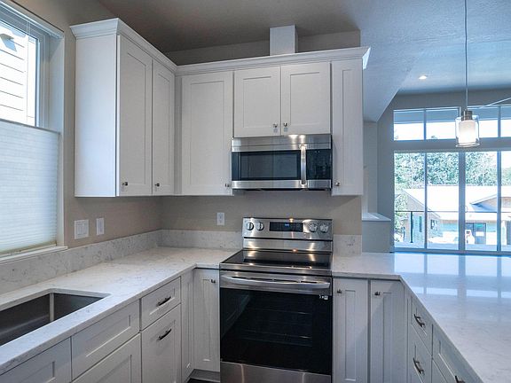 Modern kitchen with stainless steel appliances and quartz countertops with large step in pantry.