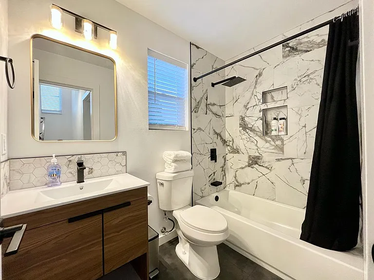 Refresh and rejuvenate: Step into our stylish bathroom featuring a modern shower and an inviting tub.