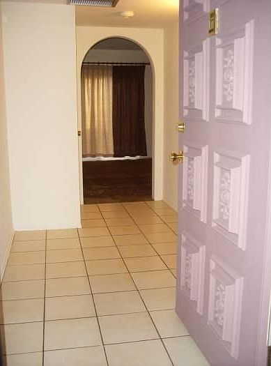 Entry into foyer (foreground) to living room beyond archway.
