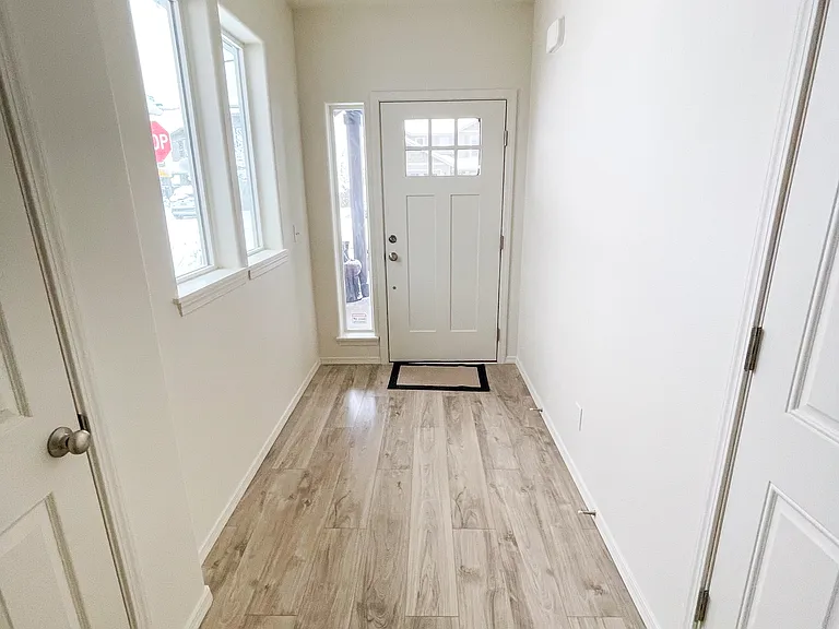 Hallway which showcases the natural light and color of walls and flooring throught the home. NOTE: Horizontal blinds currently under installation.