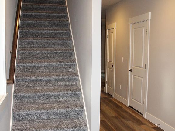 View from Entry of Stairs and Hall to Kitchen, Great Room, and Dining Room