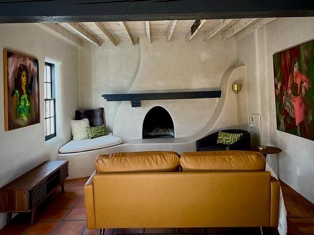 Exposed beams and dramatic fireplace add character to the living room