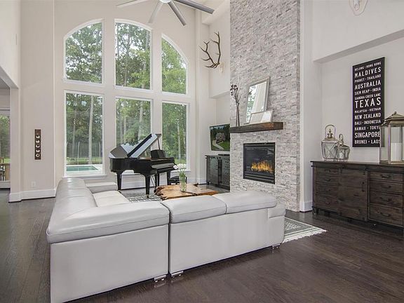 Striking Windows are the focal point with views to pool and back yard. Floor to ceiling stacked stone fireplace is flanked by two cut outs allowing functional furniture pieces or a custom built in shelving unit.