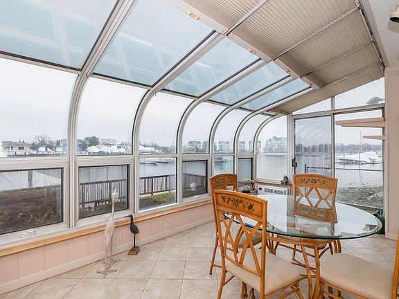 Sunroom, overlooking water and dock with door to side yard
