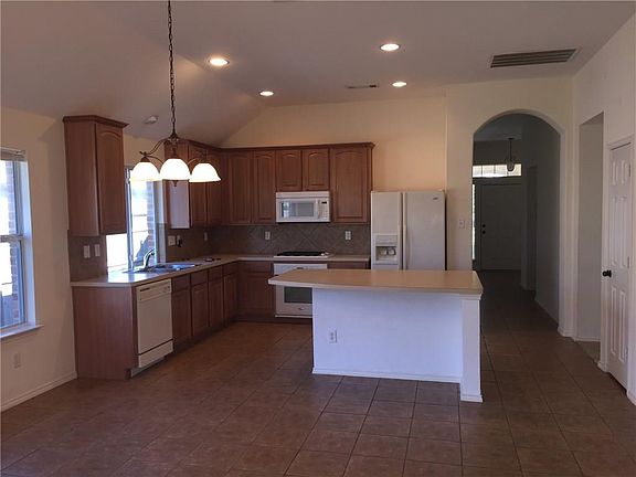 Wonderful, eat-in Kitchen has high ceilings, built-in microwave, an island - with electrical outlets, tile floor, recessed lighting, plenty of counter & cabinets space plus a pantry (Door visible on the right)