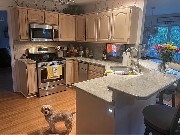 Kitchen . Gas stove. Granite countertops . Stainless appliances . Bar stools and separate sitting room full of windows .