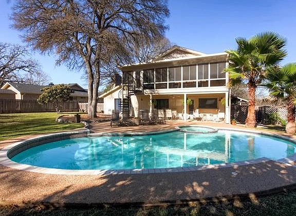 Extra large backyard with palm-tree lined pool is a great place to relax and entertain.