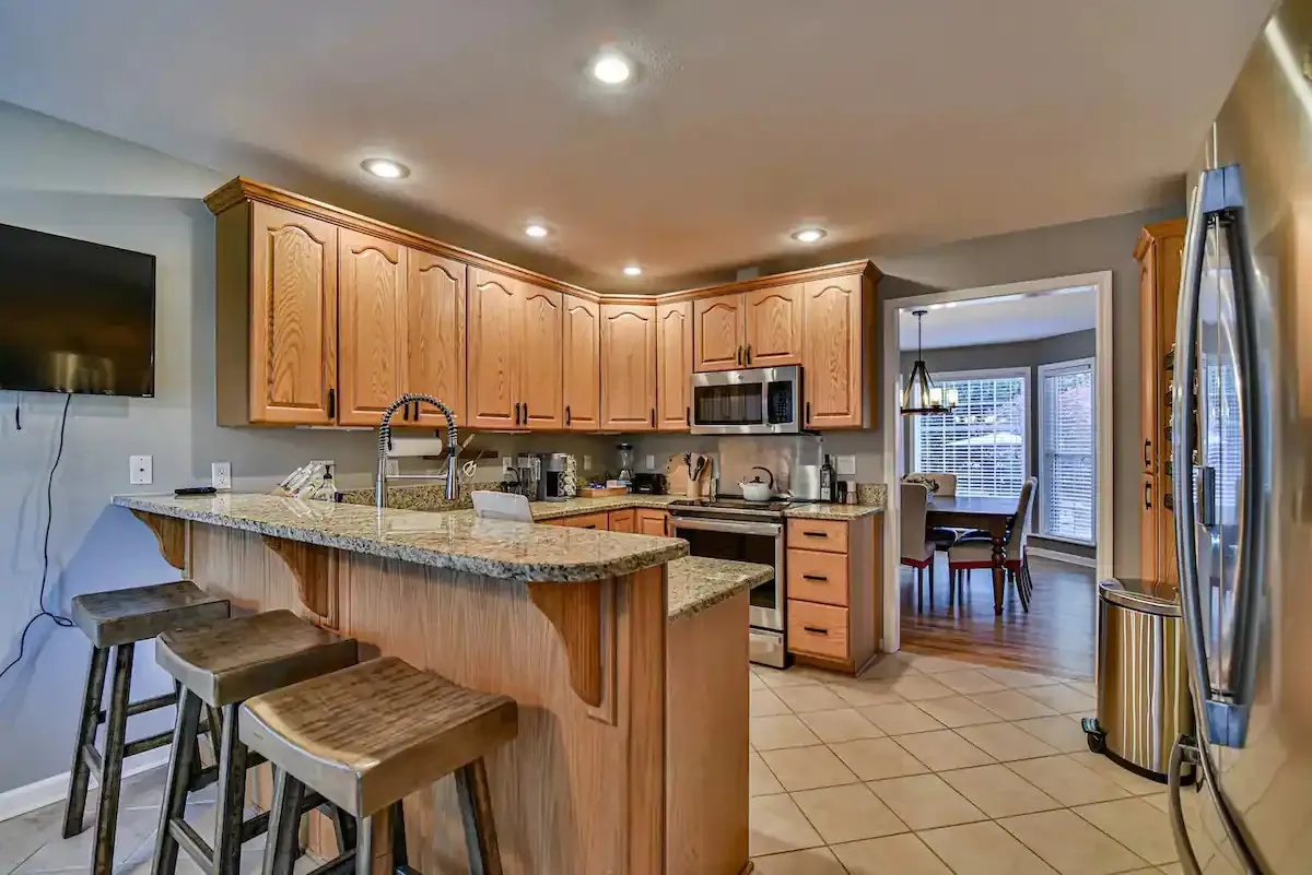 The kitchen includes a bar area with seating for up to three people, perfect for casual meals or socializing while cooking. - 16 Crestview Ct