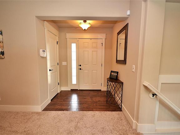 Entry leads to the Great Room and has wood flooring, coat closet, side light and door casings. The bedrooms are located to the left and the Kitchen and stairs to the walk out basement are to the right.