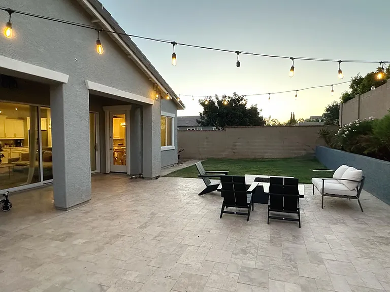 Backyard with built-in fireplace, twinkle lights, and grass