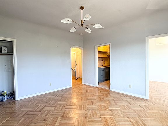 View from living room with closet, front door, kitchen, front bedroom or office area through doorway on the far right