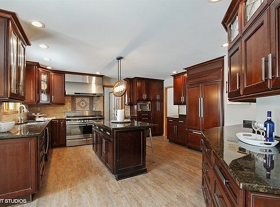 Richly appointed gourmet party kitchen, huge island, top quality appliances include professional range & hood, pantry cabinet, butler bar, Breakfast room with door to new party deck with glass railings to enjoy the wooded view.