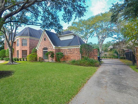 A view of the classic home showing the driveway with motorized Gate leading into the compound.