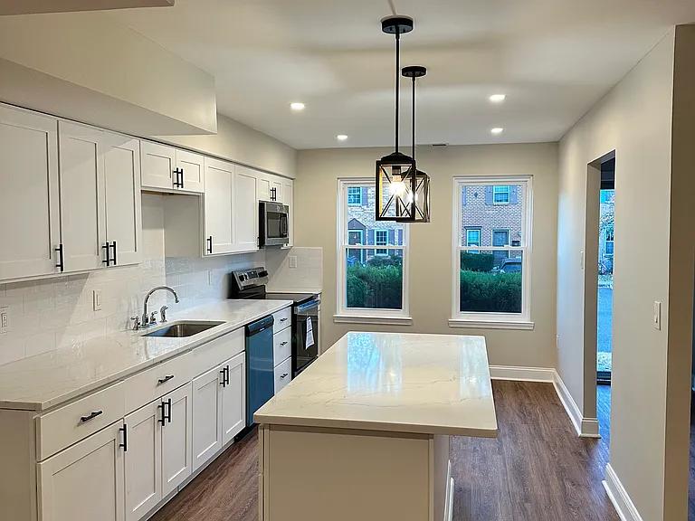 Bright, modern kitchen with brand-new stainless steel appliances, a large center island, and oversized windows bringing in incredible natural light_creating an inviting space to cook, gather, and entertain.