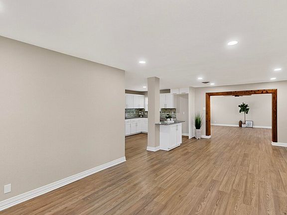 Step inside and you're welcomed by an open, airy layout with clean lines, recessed lighting, and warm wood-look flooring that instantly feels like home. It's the kind of space that makes you want to kick off your shoes and stay awhile.