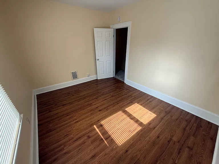 Another view of the upstairs rear bedroom, showing the entrance. New door installed in 2025.