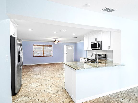 looking from the dining area into the front room and kitchen