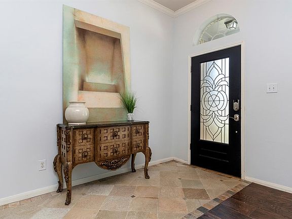 The wood and glass front door, crown moulding, tile floors and fresh paint flow throughout the home from the front door all the way to the cozy back patio.