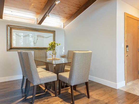 Modern dining room seating for six. Stools for 4 more on the nearby bar.
