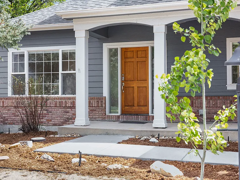 The covered front porch offers space for a pair of chairs or a small sitting area - an inviting spot to enjoy a morning coffee or unwind in the evening.