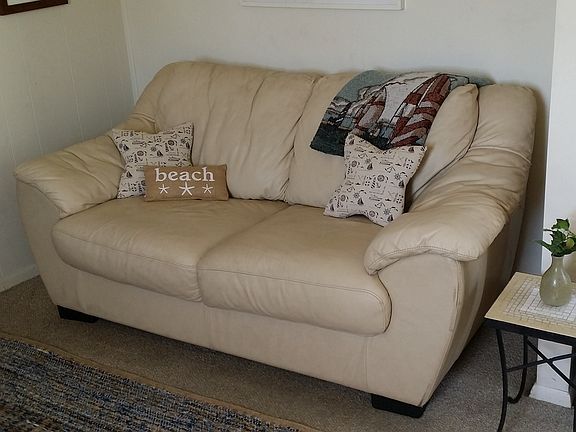 A comfortable leather sofa sits opposite the TV.