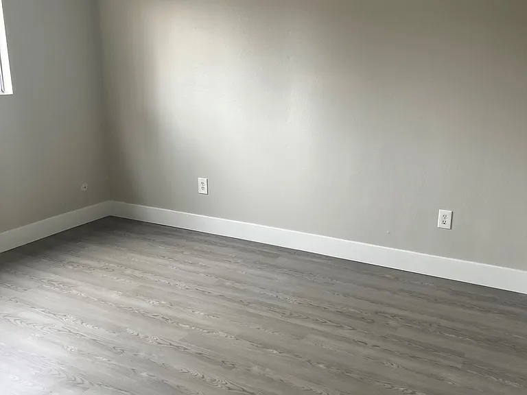 Living room with hardwood floors and natural light at IKARIA Apartments in Santee, California.