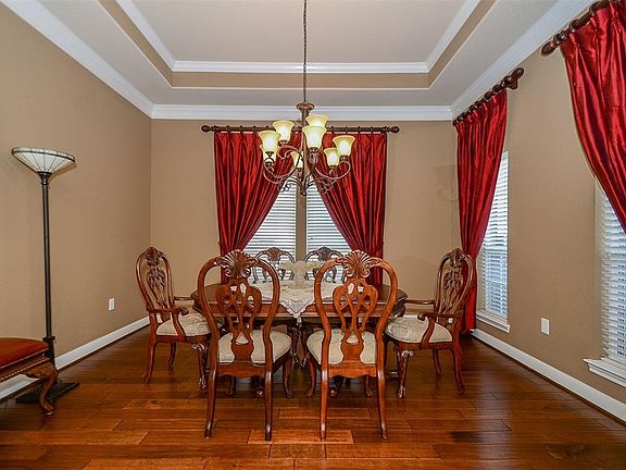 Formal dining is to the right as you walk in. Notice the trey ceiling, pretty moldings and wood flooring.