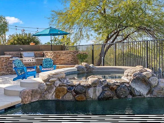 Backyard _ Feel the difference in your skin and swim in the Saltwater pebble-tec pool with two lagoons that allow umbrellas for additional shade. Soak in the 8-person spa with a beautiful waterfall feature. Pool Capable of being heated