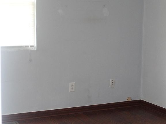 Living Room with Cherry colored laminate flooring - oversized closet in this room. Ceiling fan in living room.