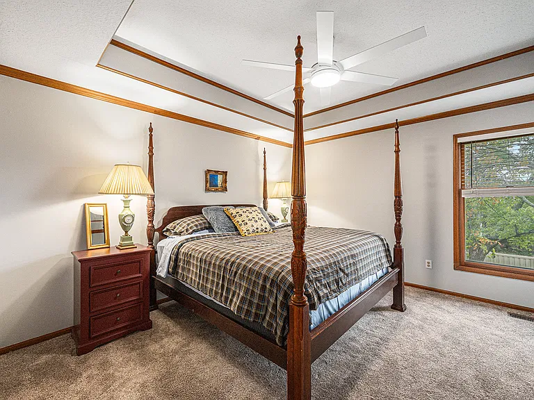 Cozy and stylish bedroom featuring a queen-size 4-poster wooden bed, perfect for comfort and a touch of timeless charm.