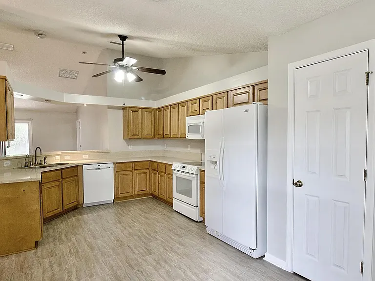 Spacious U-shaped kitchen with ample cabinetry, generous counter space, and full-size appliances for everyday cooking.