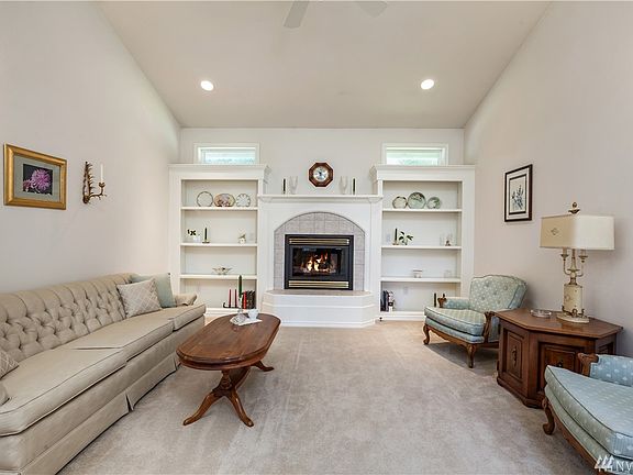 Formal dining room has gas fireplace, built-in shelving, vaulted ceilings