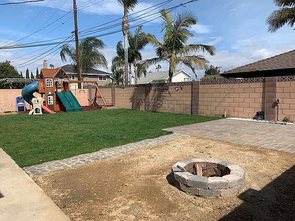 Back yard with fire pit and wooden kids' play structure.