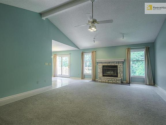 Great room with fireplace and ceiling fan.
