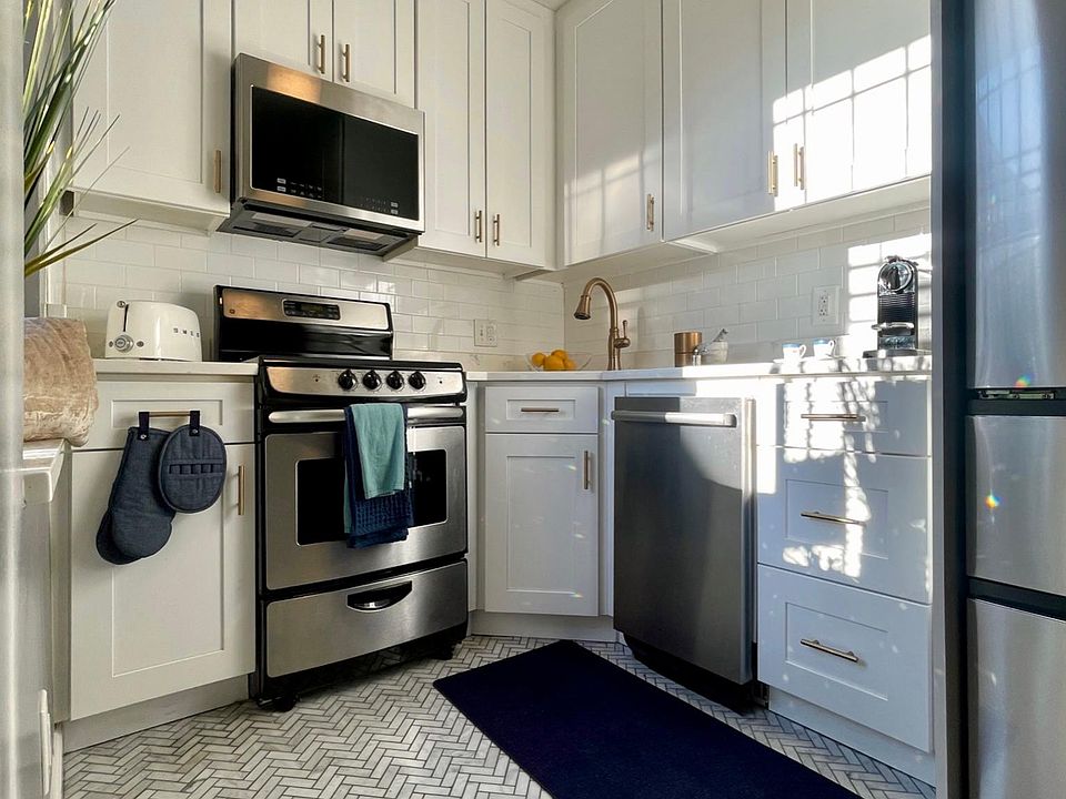 Entirely new designer kitchen features Carrara Italian marble mosaic floor. Custom sky-high cabinets for optimal storage. Brushed gold and stainless steel finishes. Large, deep sink. High end appliances.
