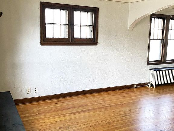Open floor plan between the living room and dining room, with warm natural wood floors