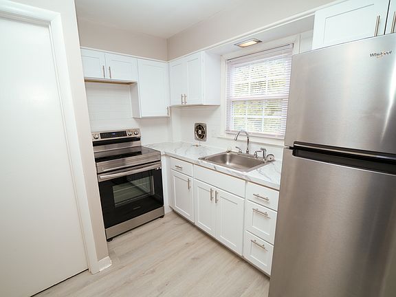 Brand new kitchen with vinyl plank flooring and new appliances. Natural light from the window over the sink.