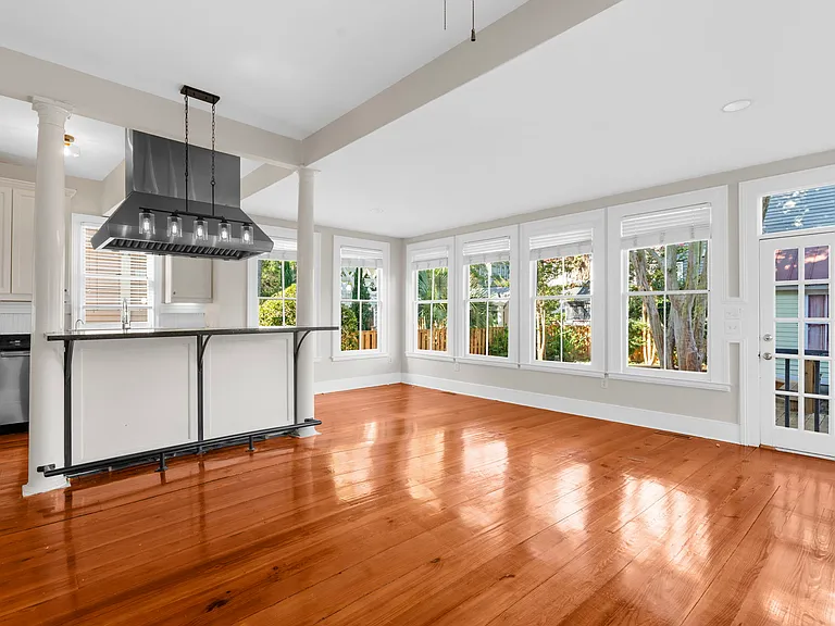 Living Room & Kitchen with Wall of Windows Looking out to the Deck and Backyard